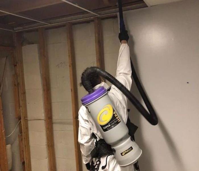 SERVPRO technician with mold remediation equipment by an open home framework