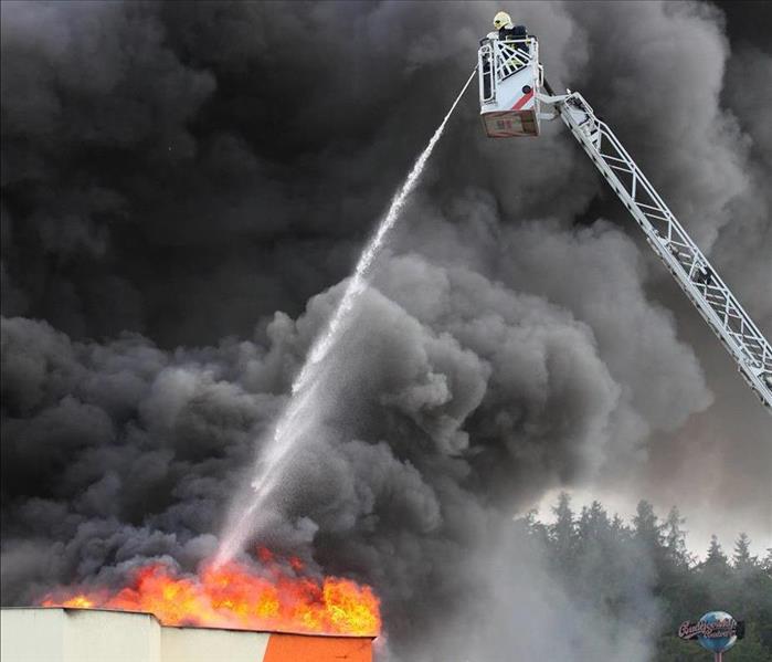 ladder truck spraying a commercial fire job