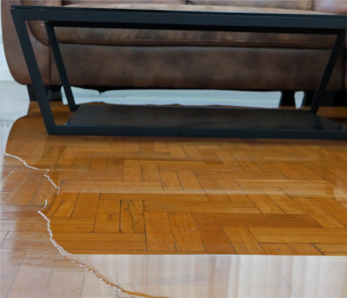 water flooding on living room parquet floor in a house