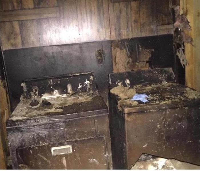 blackened surfaces of fire damage washer and drying and back wall
